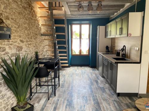 une cuisine avec une table et des chaises dans une pièce dans l'établissement Détente et spa pour se ressourcer, à Bullion