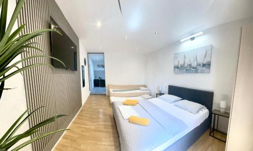 a bedroom with a large bed and a plant at Aria in Baška Voda