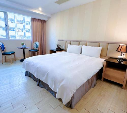 a hotel room with a large bed and a desk at Hotel Champs Elysées in Taichung