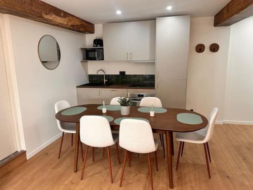 une salle à manger avec une table en bois et des chaises blanches dans l'établissement Appart 'Privilège' - Lyon Centre, à Lyon