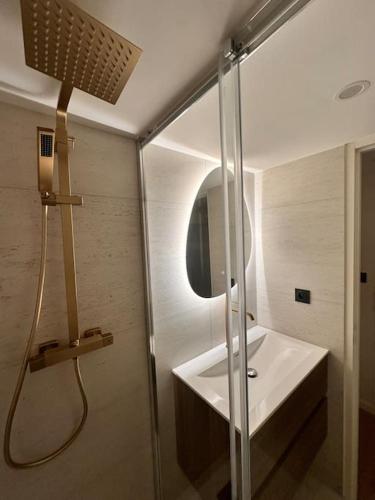 La salle de bains est pourvue d'une douche et d'un lavabo blanc. dans l'établissement Appart 'Privilège' - Lyon Centre, à Lyon