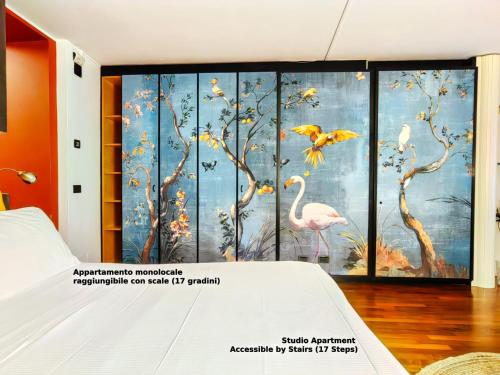 a bedroom with a mural of birds and trees at Hotel Ancora in Verbania