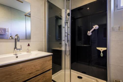 une salle de bain avec une douche en verre et un lavabo dans l'établissement The Segur Cottage, à Ségur-le-Château