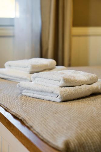 three folded towels sitting on top of a bed at Linnupesa Apartment in Viljandi