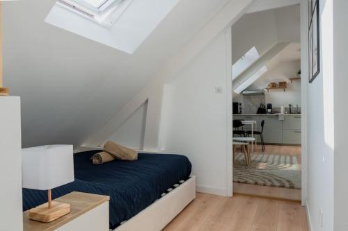 a bedroom with a blue bed in a white room at Suite Sous Velux T2 in Saint-Nazaire