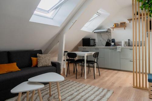 サン・ナゼールにあるSuite Sous Velux T2のソファとテーブルと椅子のあるリビングルーム