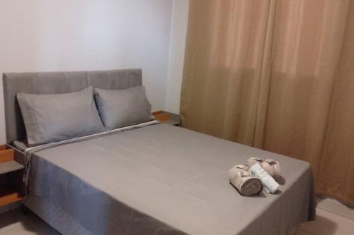 a bed with two pillows and two towels on it at Belo ap em Sete lagoas in Sete Lagoas