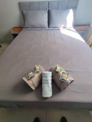 a bed with two towels on top of it at Belo ap em Sete lagoas in Sete Lagoas