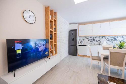 a living room with a tv and a dining room at Zoto Luxury Apartment in Himare