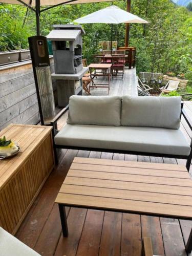 a patio with a couch and tables and an umbrella at Casa le Bouquetin in Introd