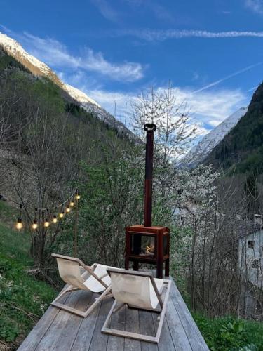 two chairs and a wood stove on a wooden table at Casa le Bouquetin in Introd
