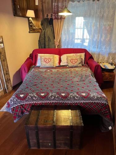a bedroom with a bed with a blanket and pillows at Casa le Bouquetin in Introd