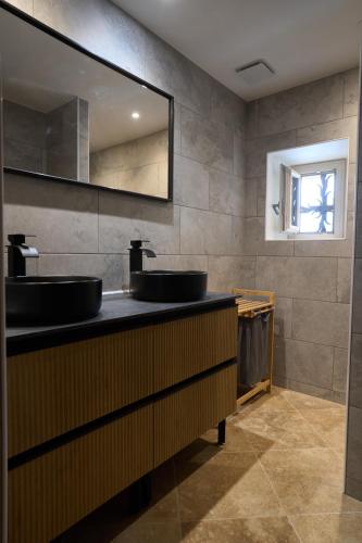 une salle de bain avec deux lavabos et un miroir dans l'établissement La charmante, au Buisson de Cadouin