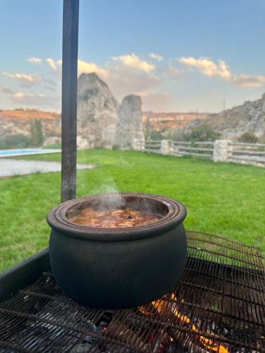 a pot of food cooking on a grill at Senfoni Cave Village in Nar