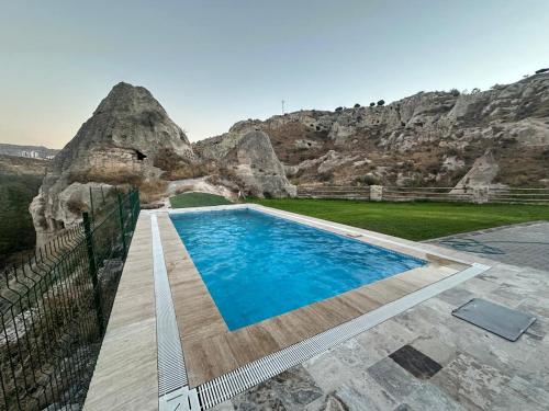 a swimming pool in front of a mountain at Senfoni Cave Village in Nar
