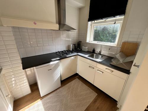 a small kitchen with white appliances and a window at Intimate independent apartment, Centre Dordrecht in Dordrecht
