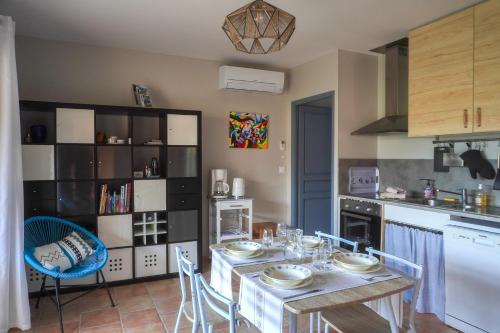 eine Küche mit einem Tisch und Stühlen in einer Küche in der Unterkunft Chez Francis & Valérie in Villegailhenc