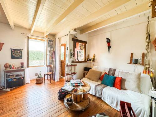 un salon avec un canapé blanc et une table dans l'établissement Escapade Authentique Charme de la Pierre, à Rochetrejoux