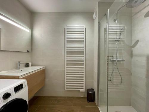une salle de bain avec douche et lavabo dans l'établissement Homency - Résidence Fermes de l'Alpe A102, à L'Alpe-d'Huez