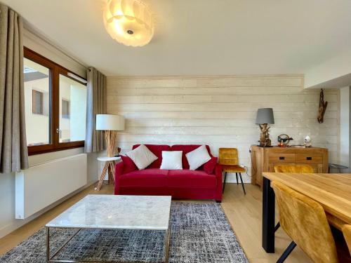 un salon avec un canapé rouge et une table dans l'établissement Homency - Résidence Fermes de l'Alpe A102, à L'Alpe-d'Huez