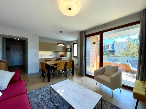 un salon avec un canapé rouge et une table dans l'établissement Homency - Résidence Fermes de l'Alpe A102, à L'Alpe-d'Huez