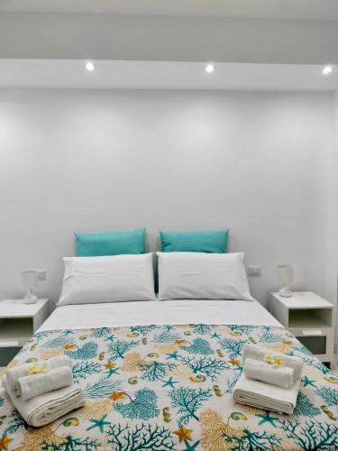 a bedroom with a large bed with towels on it at Casa Plumeria in Marinella di Selinunte