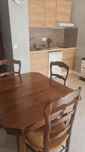 - une table et des chaises en bois dans la cuisine dans l'établissement Appartement 2 pièces équipé & rénové, à Balaruc-les-Bains