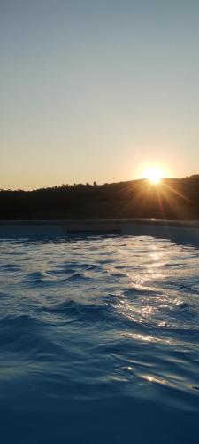 a view of the sun setting over a body of water at ElsAnto-beb in San Venanzo