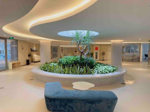 a lobby with a large fountain with a blue couch at The Sóng Luxury Apartment Vung Tau - Tuấn Hoà Homestay in Vung Tau