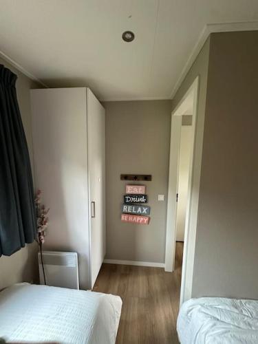 a bedroom with a bed and a wall with a sign at Boslodge Het Groene Hert met Hottub in Haarle