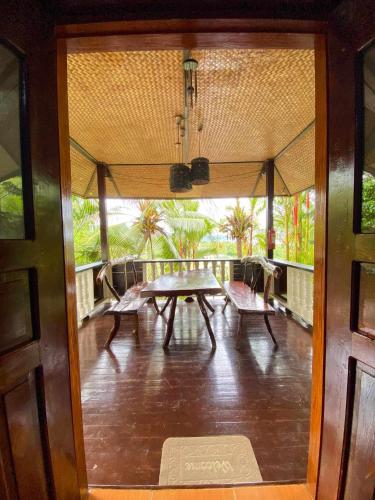 a room with a table and chairs on a balcony at Victordelia Hilltop Hostel in San Vicente
