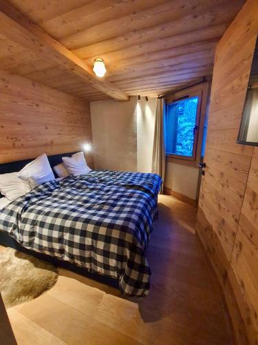 une chambre avec un lit dans une cabane en bois dans l'établissement Appartement neuf haut de gamme esprit chalet à Méribel - 4 couchages, à Méribel
