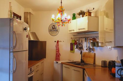  La cuisine est équipée de placards blancs et d'un réfrigérateur. dans l'établissement Minavita, à Pietrosella