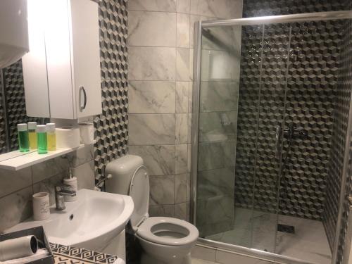 un bagno con doccia, WC e lavandino di Snow white studio a Skopje