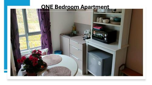 une petite pièce avec une table et un micro-ondes dans l'établissement Kensington Sunrise sg, Palas Horizon,kea farm, à Brinchang