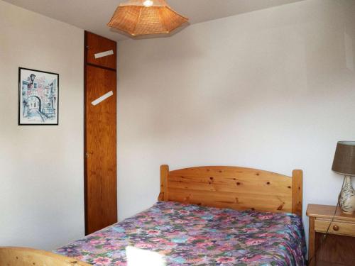 une chambre avec un lit avec une tête de lit en bois dans l'établissement Appartement pour 6, accès direct aux pistes, balcon, animaux admis - FR-1-322-541, aux Orres
