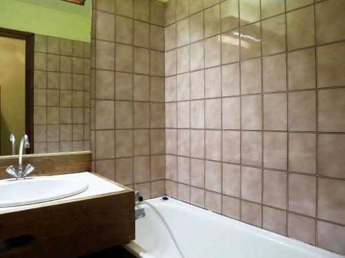 une salle de bain avec une baignoire et un lavabo et une baignoire dans l'établissement Studio 4 pers. accès direct pistes, centre et balcon sud - FR-1-322-555, aux Orres