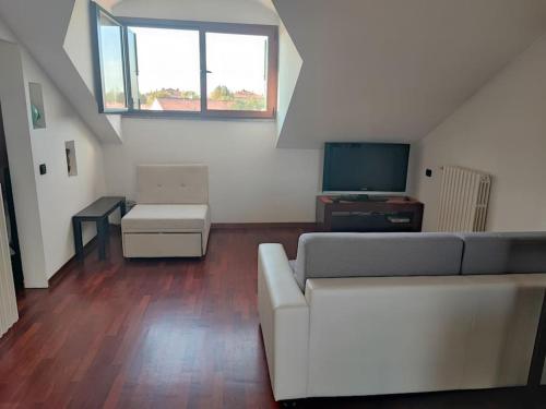 a living room with a white couch and a television at Un posto tranquillo a Milano in Milan