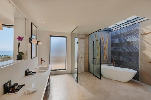 a bathroom with a tub and a sink and a shower at Herbert Samuel Royal Shangri-La Eilat in Eilat