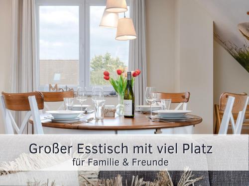 une salle à manger avec une table avec des fleurs rouges dessus dans l'établissement Lotsenglück Fehmarn, Nähe Hafen Burgstaaken, perfekt für Familien & Paare, à Burg