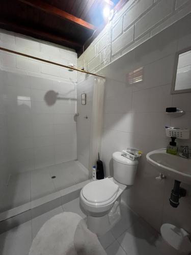 a white bathroom with a toilet and a sink at Finca la frondosa - La frondosa farm in Angelópolis