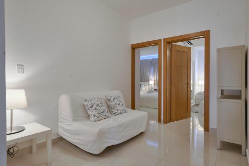 a white living room with a couch and a table at Apartments in La Julia 1 and 2 Bedrooms in Santo Domingo