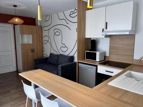 - une cuisine avec une table et un canapé dans une chambre dans l'établissement Boudoir Margot - Luxury room balnéo, à Vichy