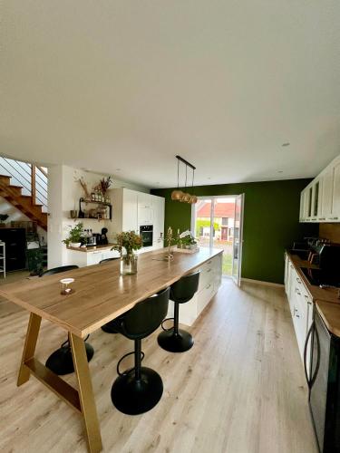 une grande cuisine avec une table et des tabourets en bois dans l'établissement La Perle du Bel Etage, à Mailly-sur-Seille