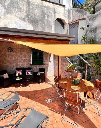 a patio with a table and chairs and a yellow umbrella at Isabel’s house in Vietri sul Mare