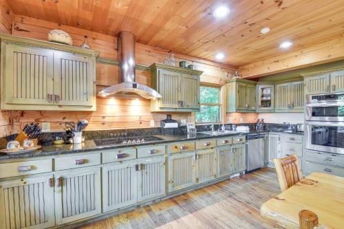 a large kitchen with wooden walls and wooden floors at Expansive Sky Valley Lodge with Mountain Views! in Sky Valley