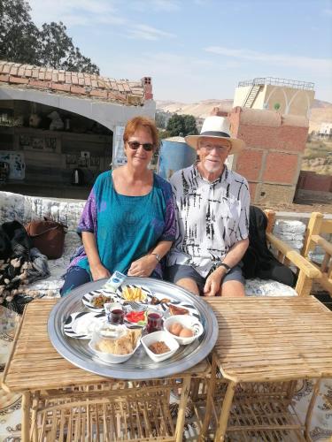 a man and woman sitting at a table with a tray of food at Nubian Life Nile View in Aswan