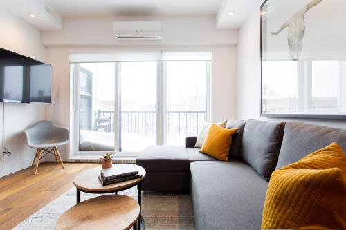 a living room with a couch and a table at Sleek Condo in the Heart of Little Italy by Den Stays in Montréal