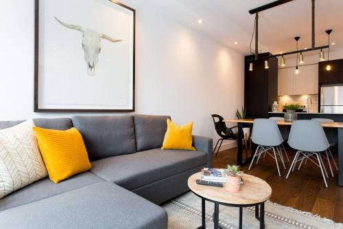 a living room with a couch and a table at Sleek Condo in the Heart of Little Italy by Den Stays in Montréal