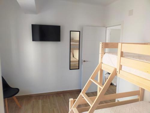 a room with a bunk bed and a television on a wall at Moderno Apartamento en Peñíscola Centro, cerca de la Playa y el Castillo Papa Luna in Peñíscola